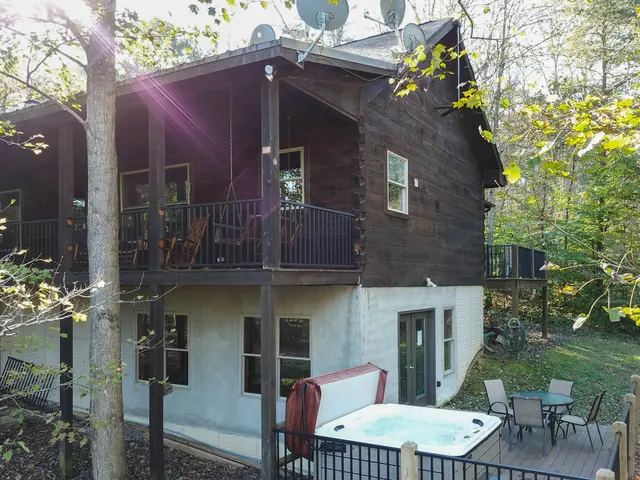 Back of the cabin with the upper deck, lower patio and hot tub