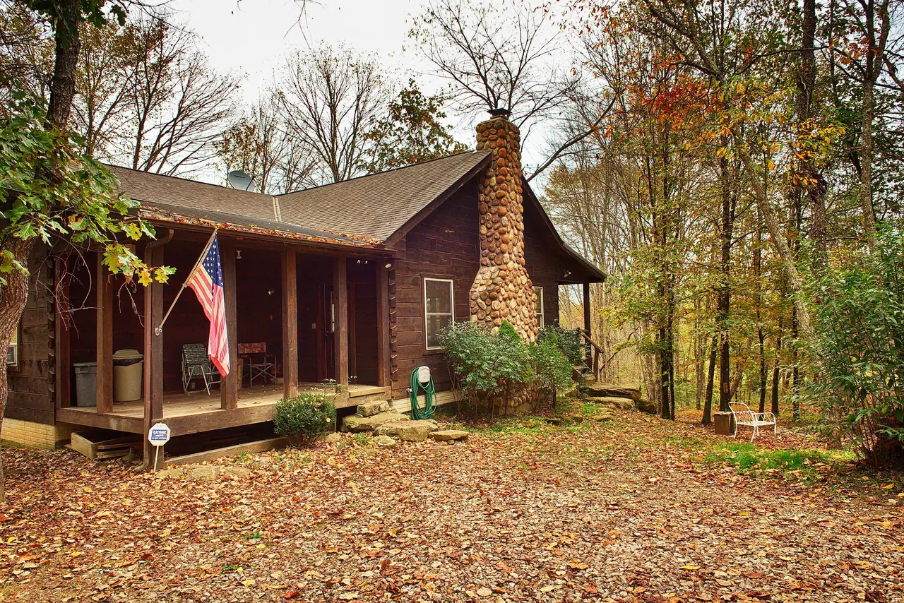 Cabin front porch with fall leaves covering the yard