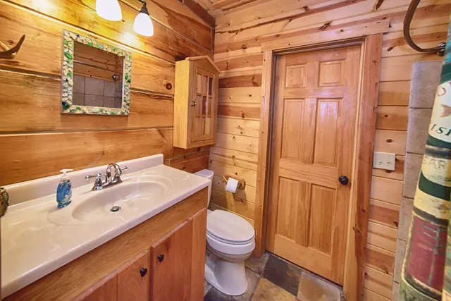 Bathroom with log walls and a wood vanity