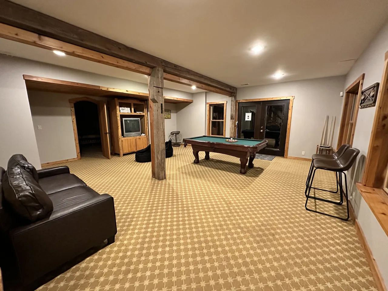 Lower-level game room with a pool table and leather sofa
