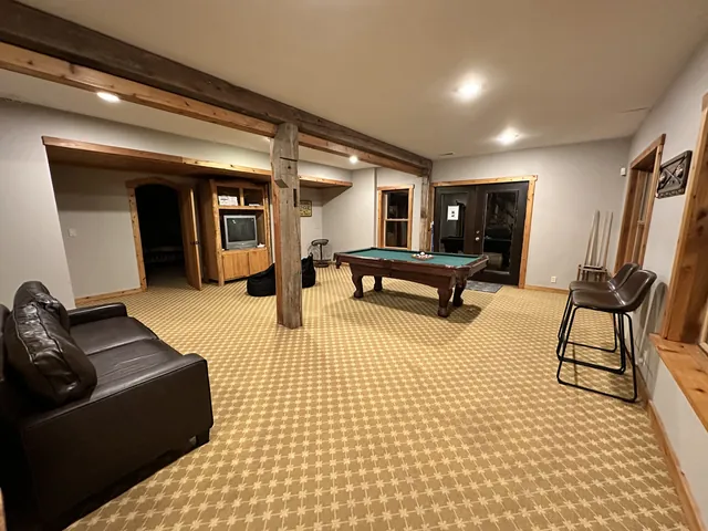 Lower-level game room with a pool table and leather sofa