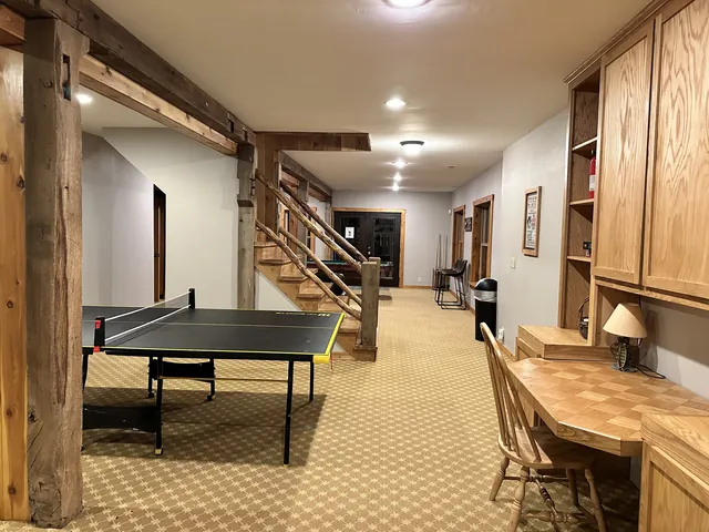 Lower level with the ping pong table, a built-in desk and the stairs