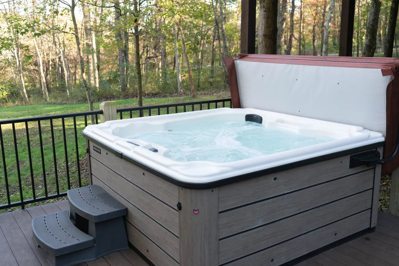 Private hot tub on the back deck of our Hocking Hills cabin with hot tub, looking out to the woods