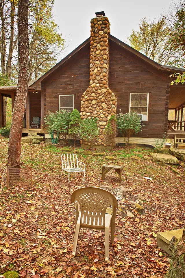 Stone chimney side of the cabin in autumn